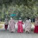 Women walk down a road in historical period dress in Colonial Williamsburg