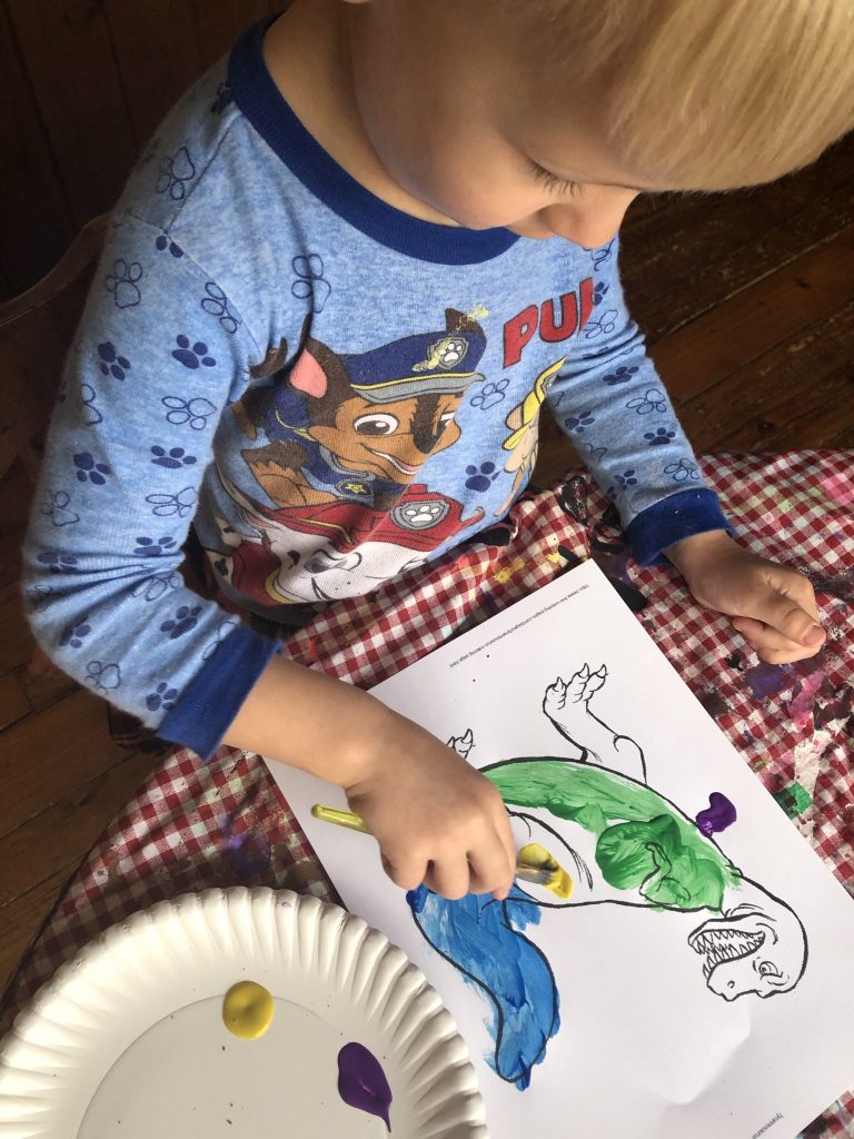 pre-school boy paints dinosaurs